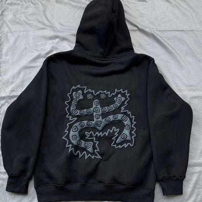 Black oversized hoodie with a geometric pattern on the front, displayed on a grey background.
